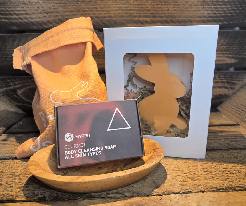 Ein stilvoll arrangiertes Wellness- und Relax-Geschenkset mit hochwertigen, handgemachten Produkten aus Griechenland, darunter eine Körperseife mit Geranie, eine handgefertigte Seifenschale aus Olivenholz und eine duftende Bienenwachskerze in Hasenform. Perfekt kombiniert für Entspannung und Pflege im mediterranen Flair – ein besonderes Ostergeschenk, das Körper und Seele verwöhnt.