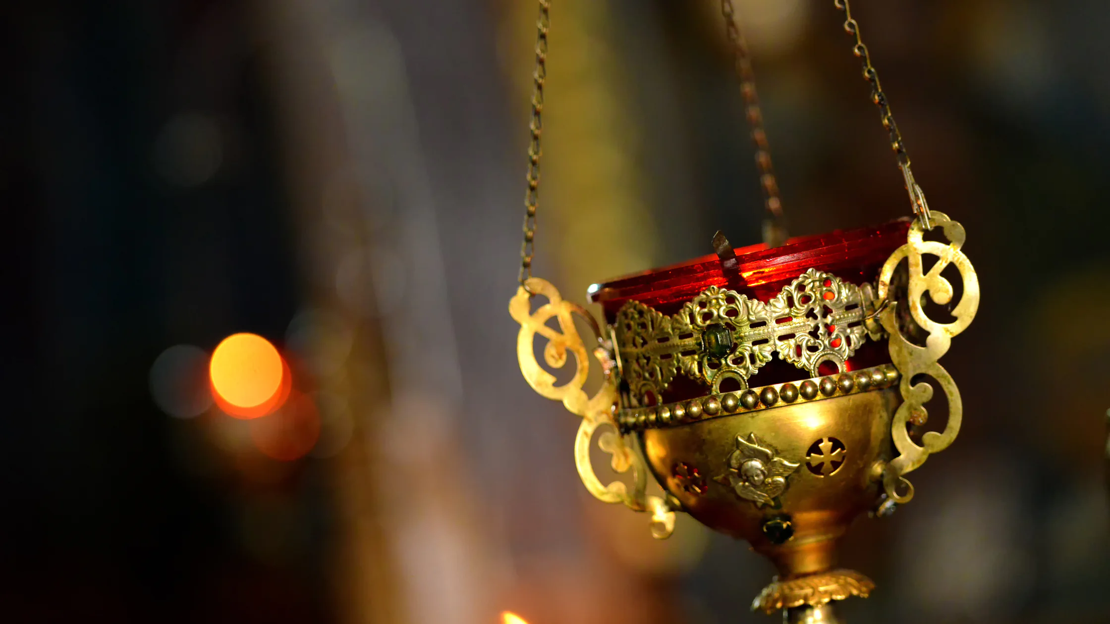 Goldene orthodoxe Kirchenreliquien mit Räucherschale, umgeben von brennenden Kerzen im Inneren einer griechisch-orthodoxen Kirche während des Osterfestes.